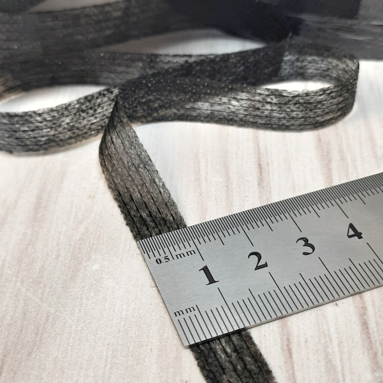 Тасьма ниткопрошивна клейова дольова, 10 мм, чорна ,моток  100м