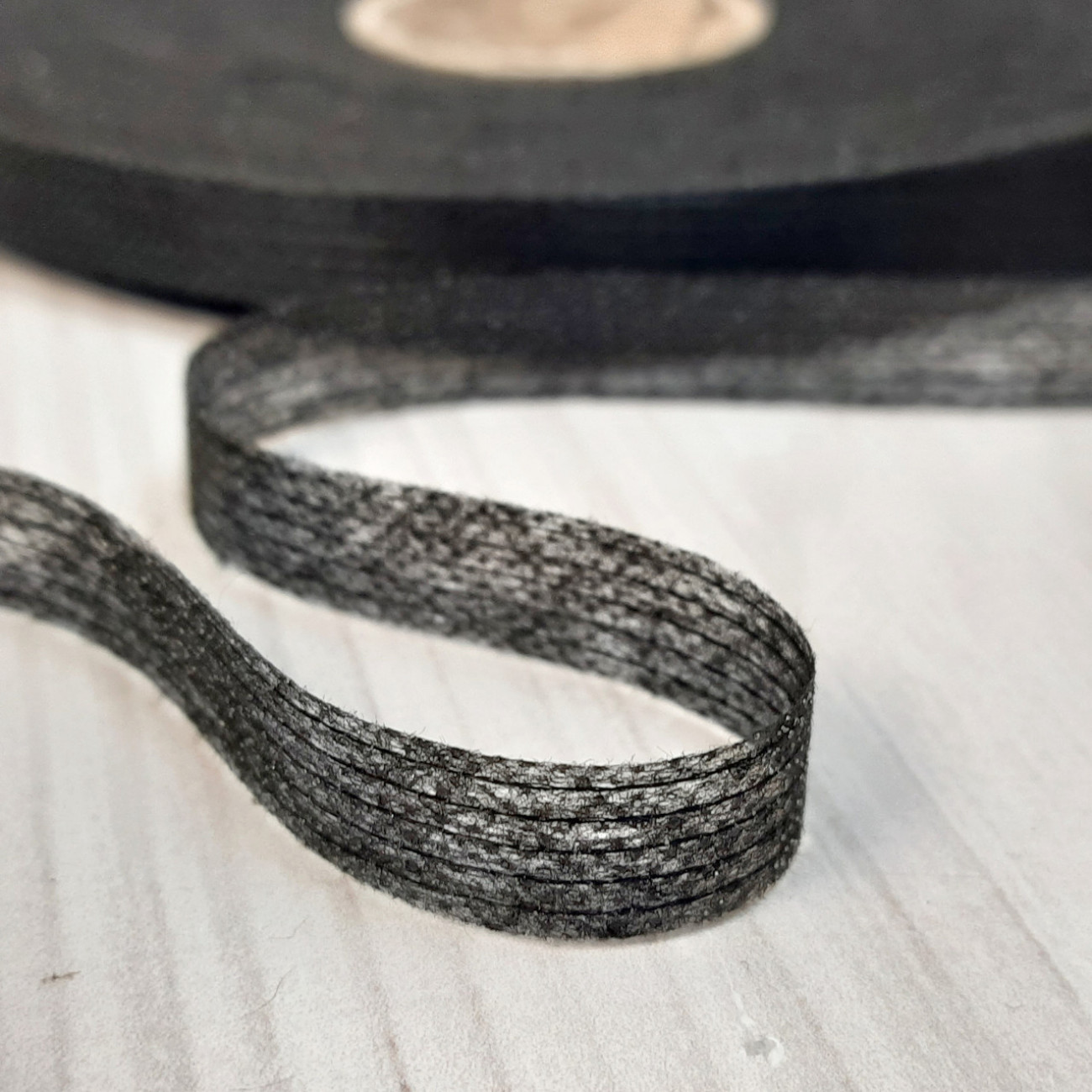 Тасьма ниткопрошивна клейова дольова, 10 мм, чорна ,моток  100м