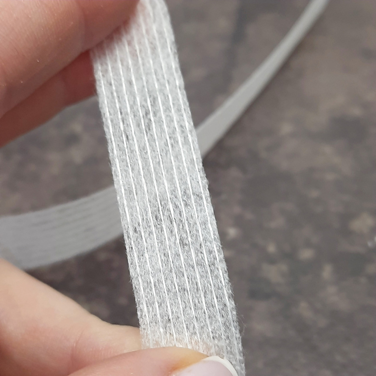 Тасьма ниткопрошивна клейова дольова, 15 мм, біла ,моток 100м