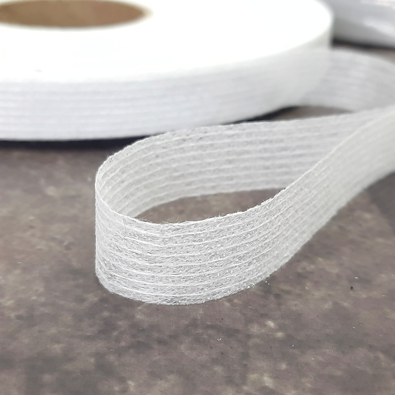 Тасьма ниткопрошивна клейова дольова, 15 мм, біла ,моток 100м