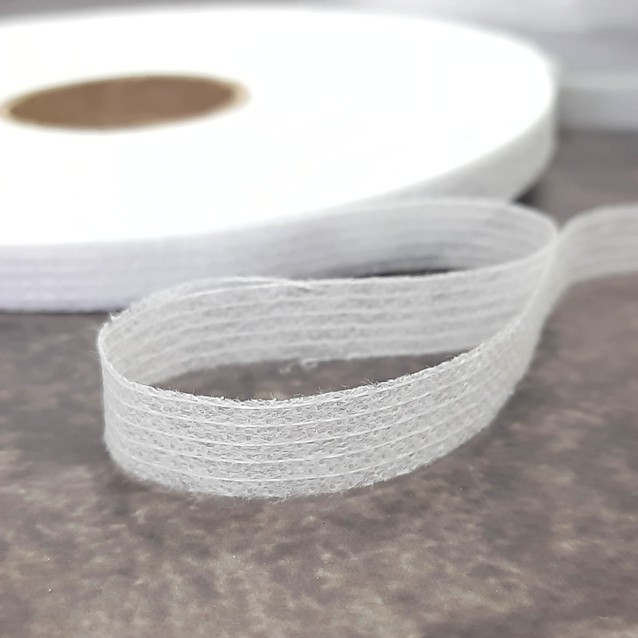 Тасьма ниткопрошивна клейова дольова, 10 мм, біла ,моток 100м