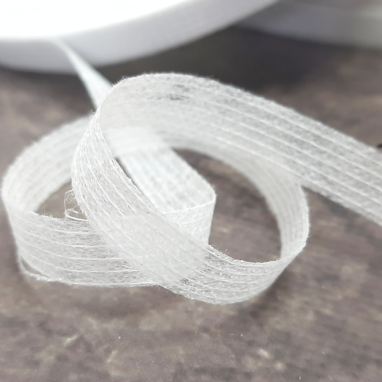 Тасьма ниткопрошивна клейова дольова, 10 мм, біла ,моток 100м