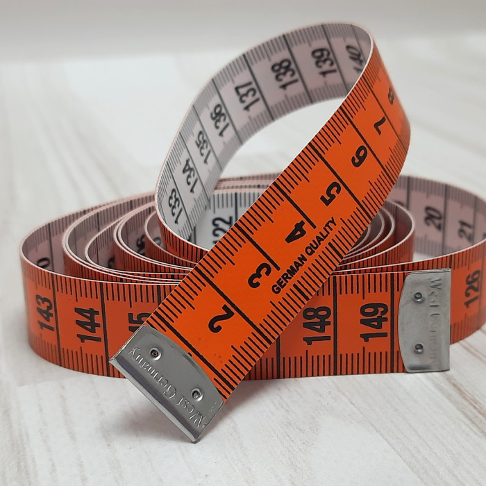 Сантиметрова стрічка помаранчево-біла з металевими накінечниками