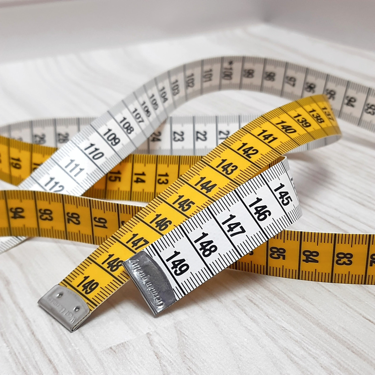 Сантиметрова стрічка жовто-біла з металевими накінечниками