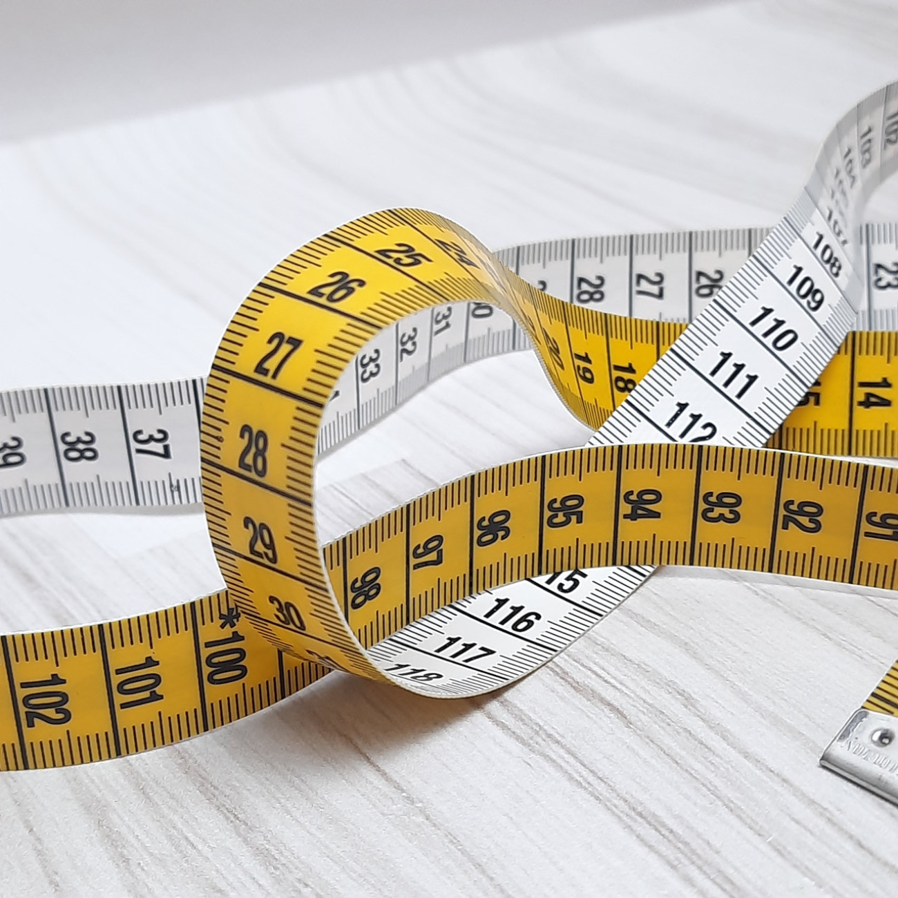 Сантиметрова стрічка жовто-біла з металевими накінечниками