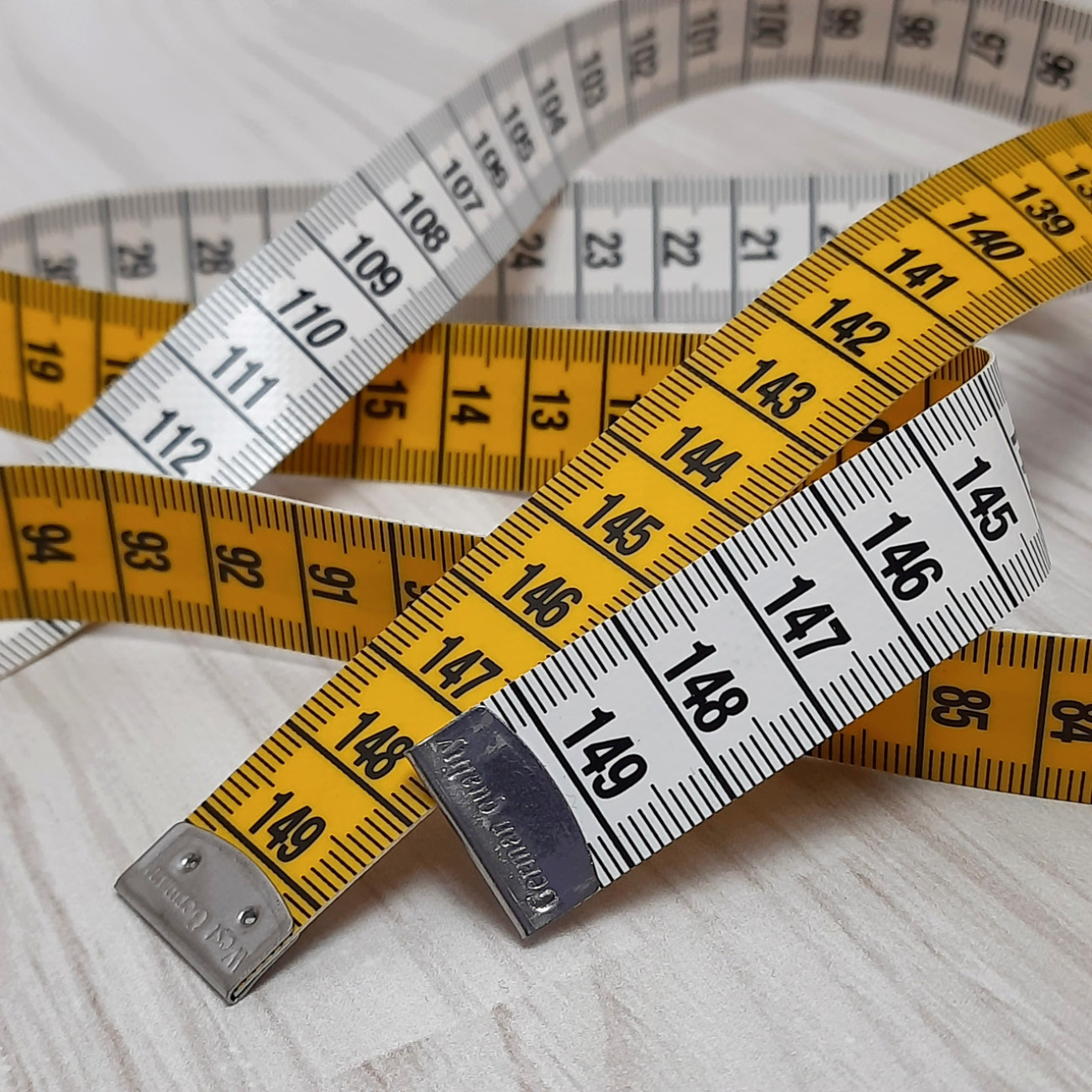 Сантиметрова стрічка жовто-біла з металевими накінечниками