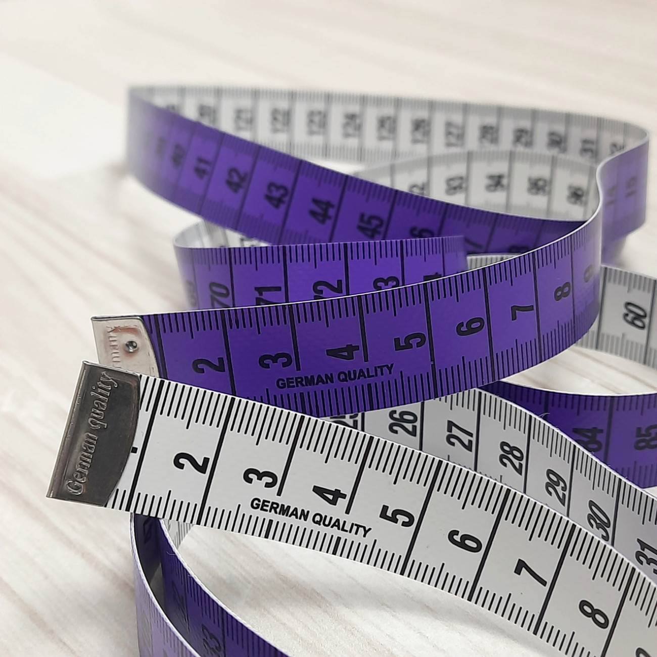Сантиметрова стрічка фіолетово-біла з металевими накінечниками