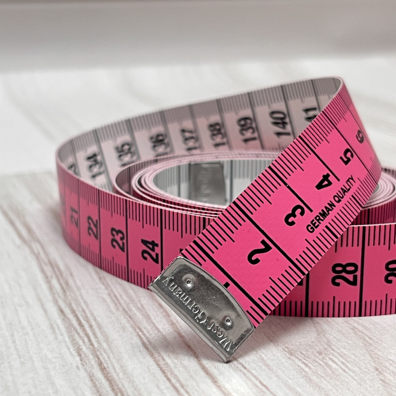 Сантиметрова стрічка рожево-біла з металевими накінечниками
