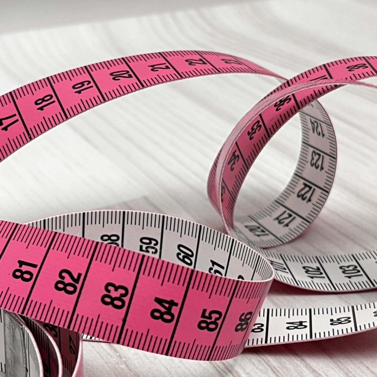 Сантиметрова стрічка рожево-біла з металевими накінечниками