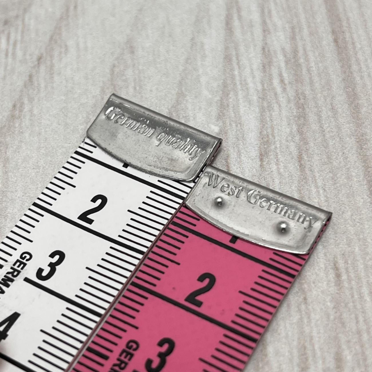 Сантиметрова стрічка рожево-біла з металевими накінечниками