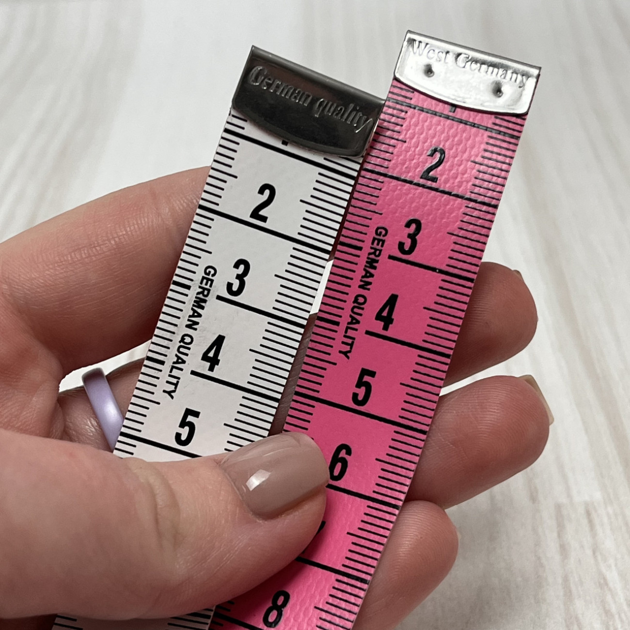 Сантиметрова стрічка рожево-біла з металевими накінечниками