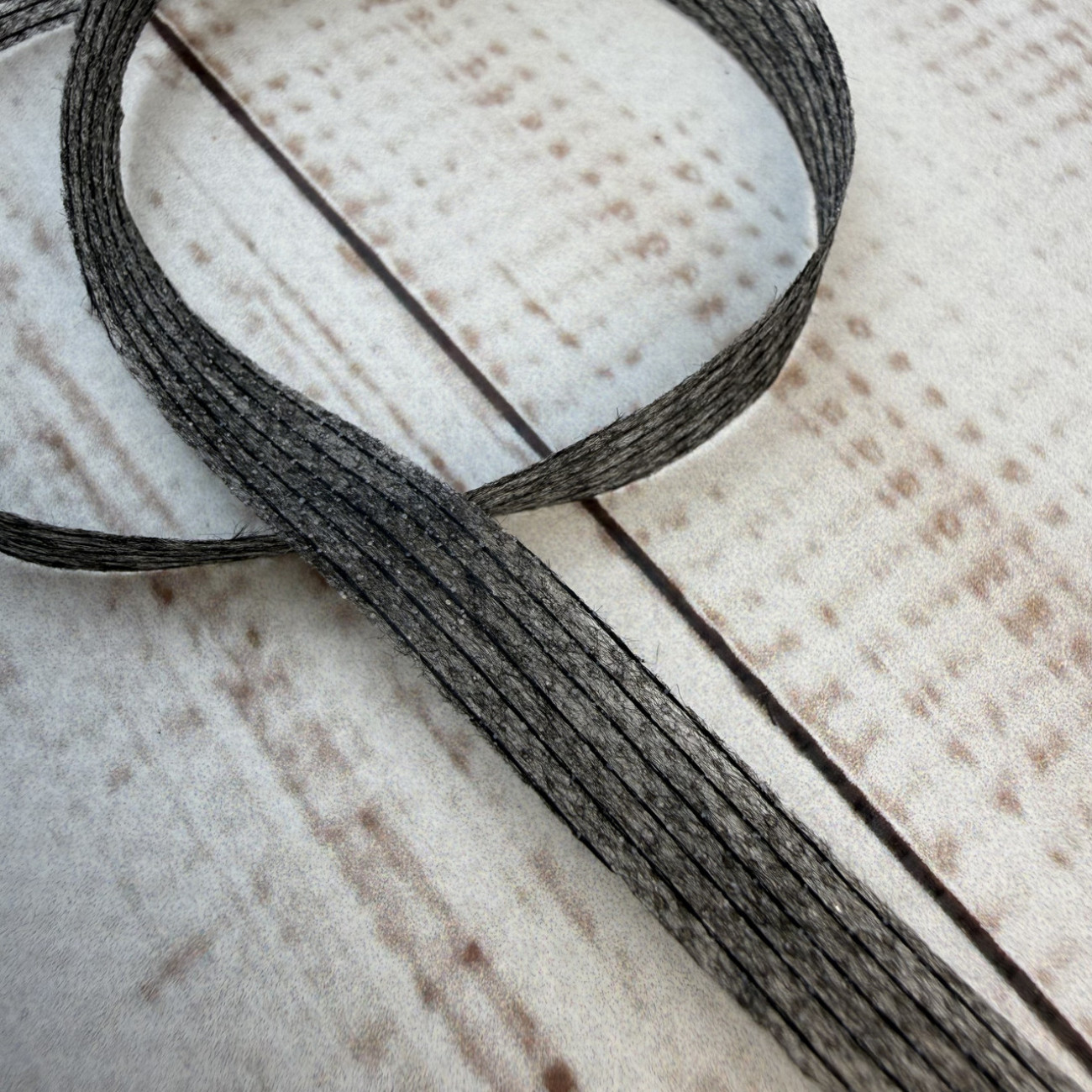 Тасьма ниткопрошивна клейова дольова, 10 мм, сіра, моток  100м